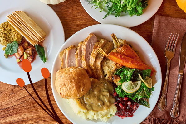 Thanksgiving plate at Lola restaurant in Seattle with sliced turkey, mashed potatoes and gravy, stuffing, roasted carrots, braised greens with lemon, cranberry-pomegranate relish, and a buttered roll.