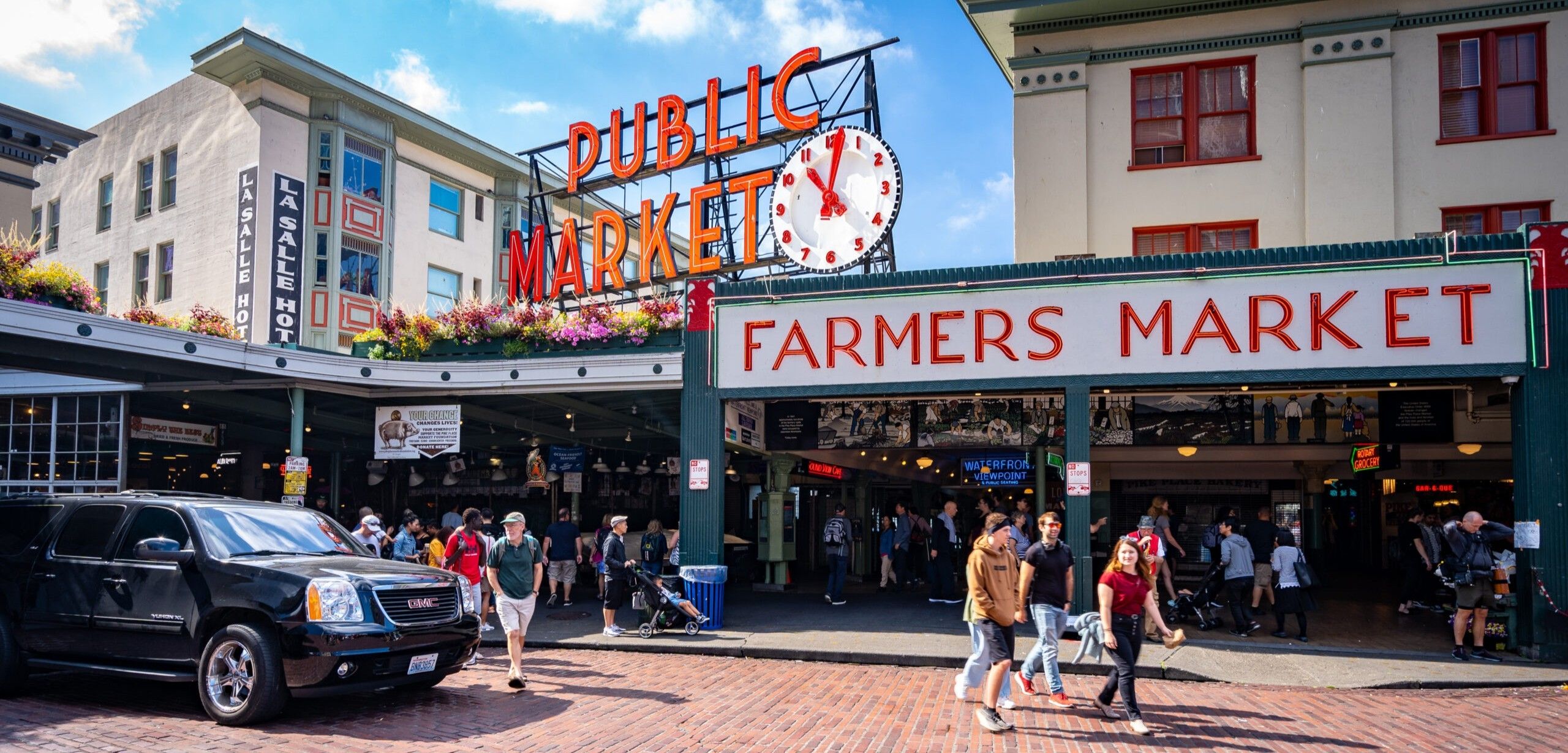 Pike Place Market entrance in downtown Seattle with iconic Public Market Center sign and crowds of visitors near Hotel Ändra
