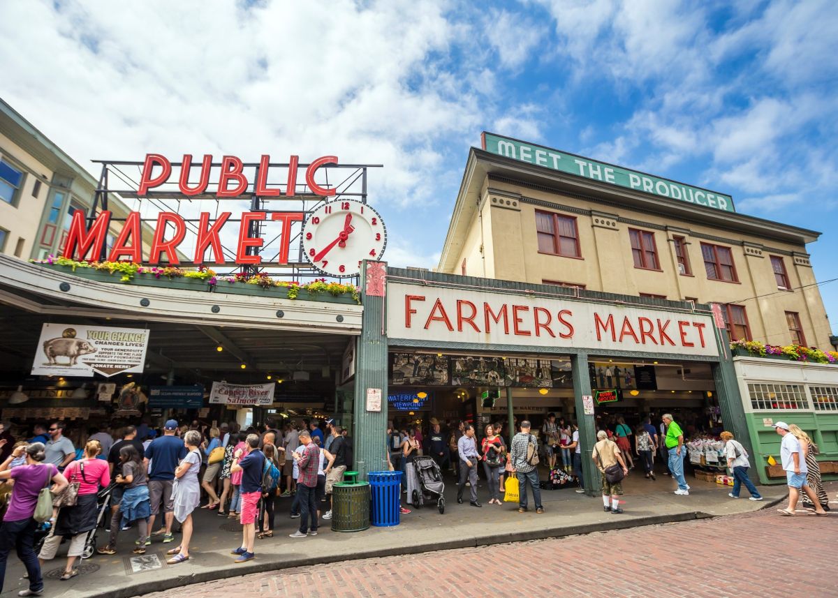 Pike Place Market entrance with iconic Public Market sign and bustling crowd of shoppers at Seattle's famous farmers market